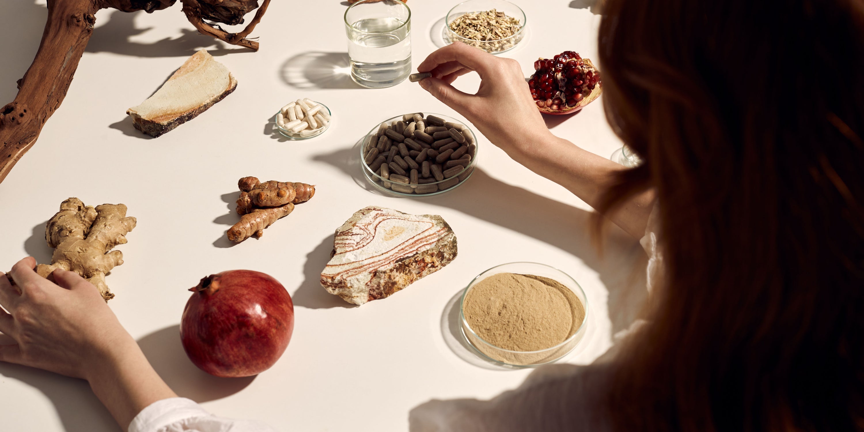 weiblich gelesenes Modell sitzt vor verschiedenen Inhaltsstoffen