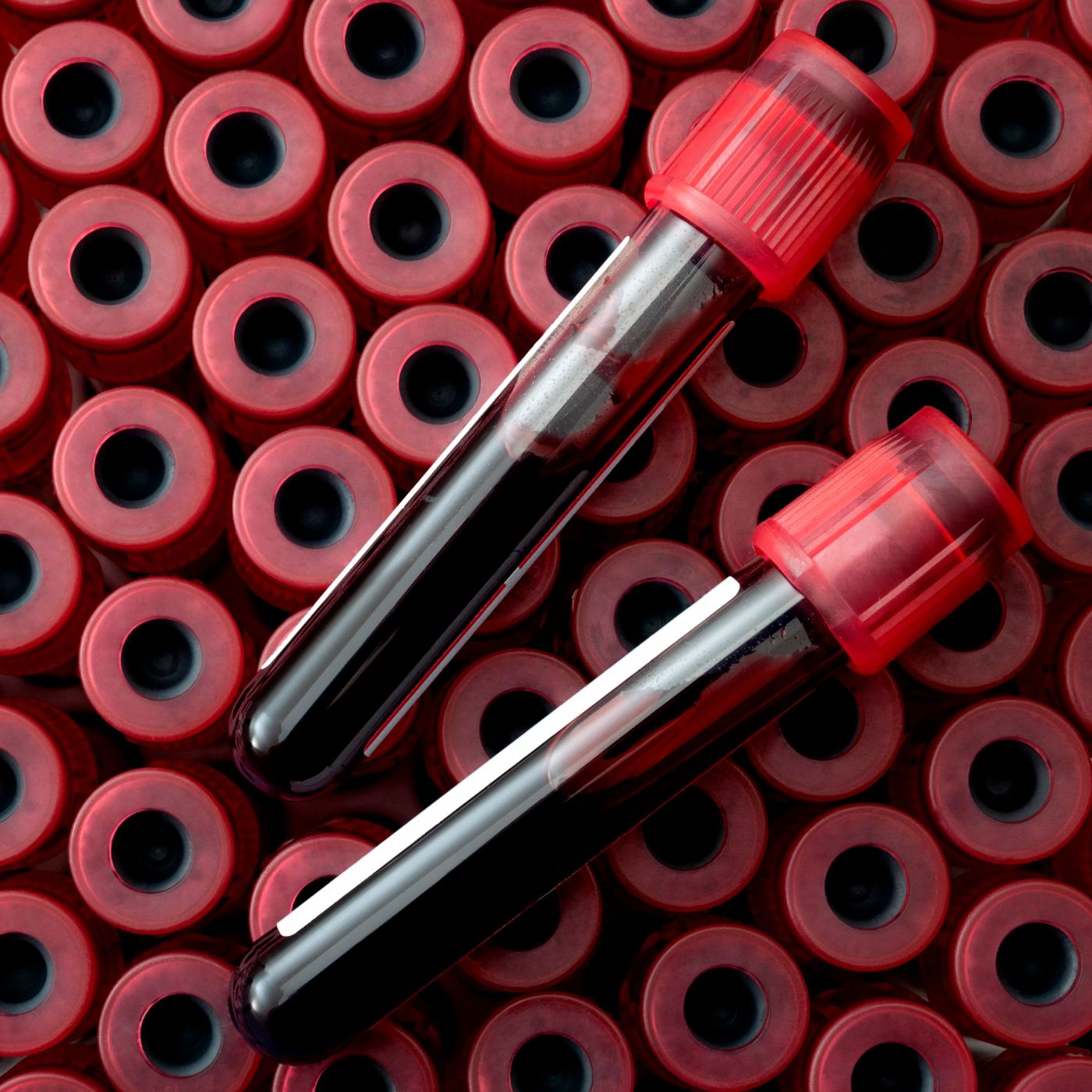 zwei Blutgefüllte Röhrchen liegen auf weiteren Abnahmeröhrchen